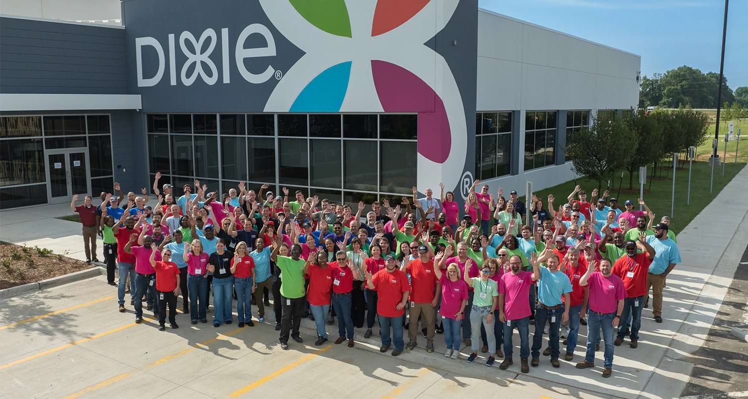 workers standing and waving in front of the dixie workplace