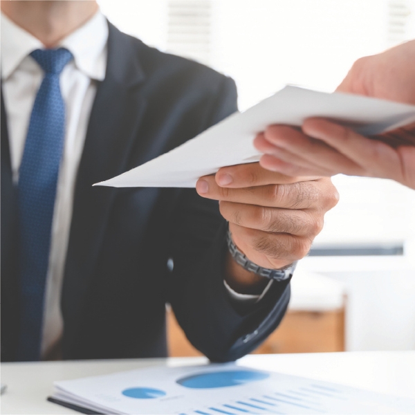 Close-up of a businessperson handing over a document.