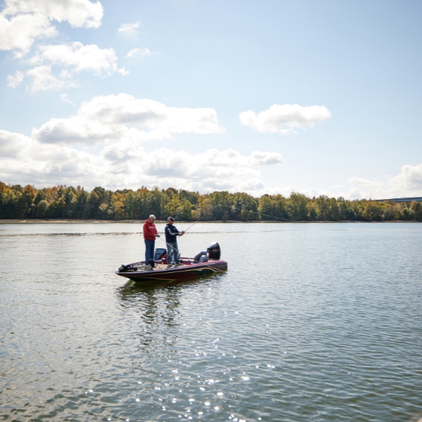 two men fishing off the side of a boat