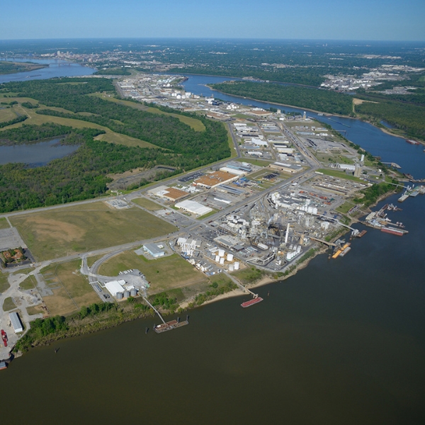Aerial view of an industrial riverport with warehouses and barges along the water