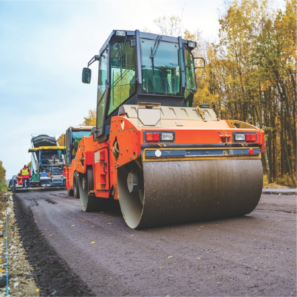 Asphalt roller machine working on a road construction site.
