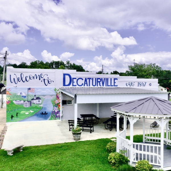 building with welcome to decaturville mural on the side
